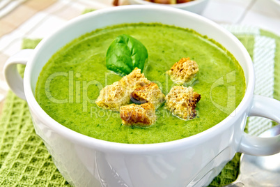 Soup puree with spinach leaves and spoon on napkin