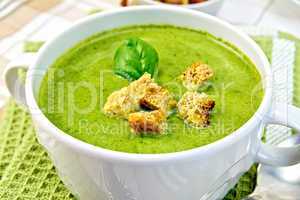 Soup puree with spinach leaves and spoon on napkin