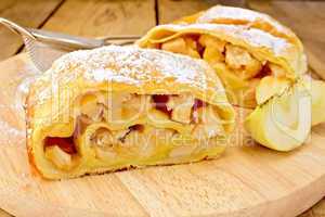 Strudel with apples and strainer on board