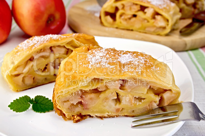 Strudel with apples in bowl on linen tablecloth