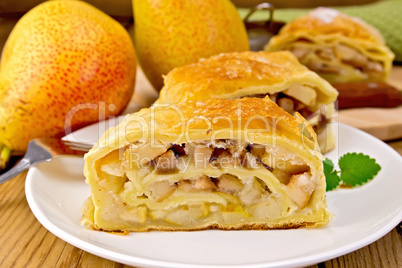 Strudel with pears and mint in bowl on board