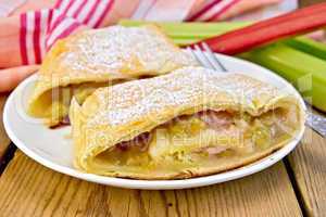 Strudel with rhubarb and fork in plate on board