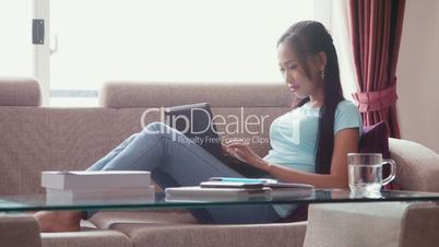 1of22 Asian girl at home with computer, phone and book