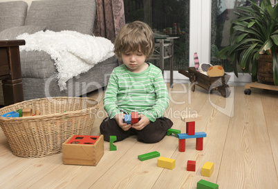 boy playing with wooden blocks
