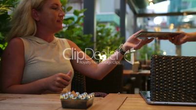 Woman paying for cafe by credit card reader