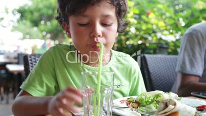 Hungry child eating at the restaurant