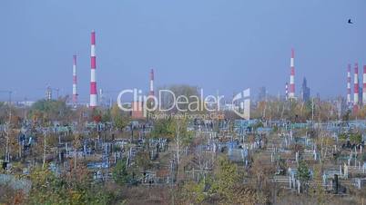 Cemetery on the background of an oil refinery