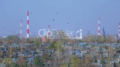 Cemetery on the background of an oil refinery, horizontal panorama