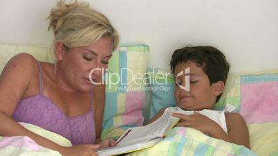 Mother reading to son in bed