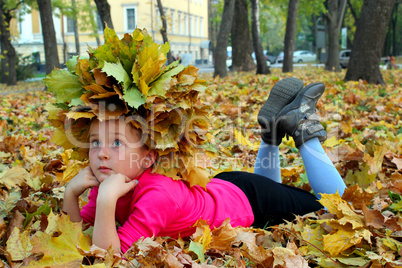 little girl lying on the yellow leaves