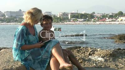 Mother and son   on beach taking selfie