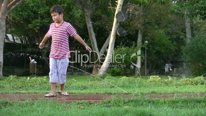 Boy relaxing with sprinklers  in the garden