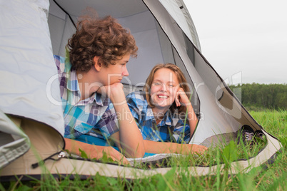 Teenage boy and girl near a white tent