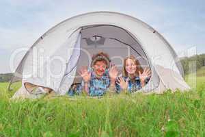 Teenage boy and girl near a white tent