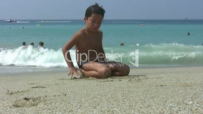 Child playing with sand on the beach