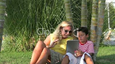 Mother and son using digital tablet in the park