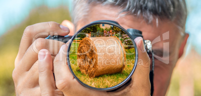 Photographer taking photo with DSLR camera at Hay Bales. Shallow