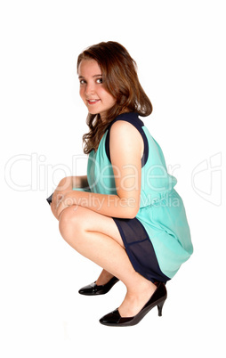 Teen girl crouching on floor.