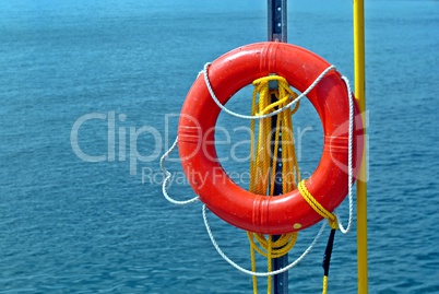 Orange life ring and rope by water