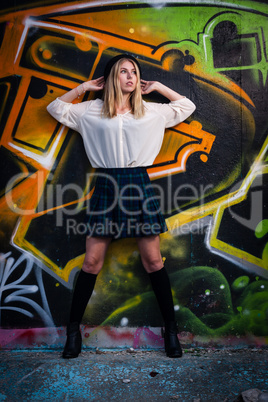 Blonde girl in front of graffiti