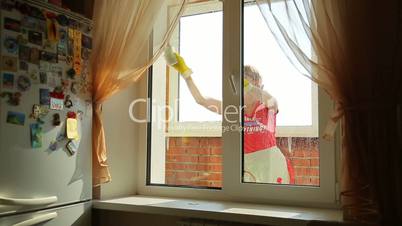 Girl washes the window, view from the front