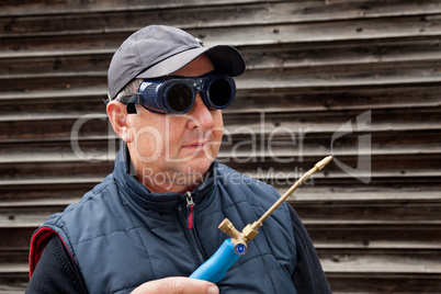 Construction worker with goggles and gas burner