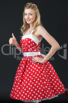 Frau im Rockabilly Kleid zeigt Daumen hoch