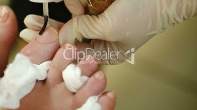 Applying a nail polish during pedicure