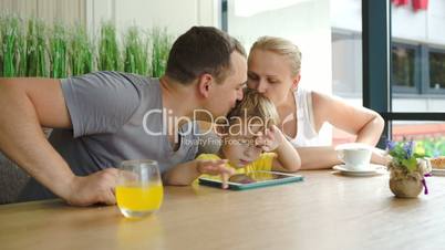 Family of three with pad in cafe