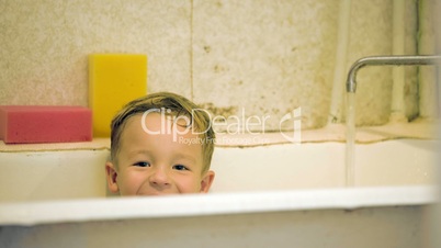 Little smiling boy sitting in bath