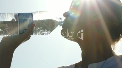 Woman drinking water in sunlight
