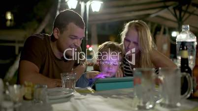 Family with tablet PC in outdoor cafe