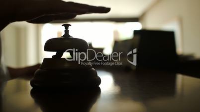 Woman ringing reception bell in hotel