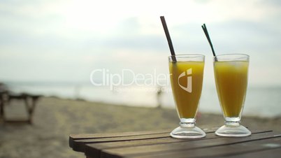 Two cocktails on wooden table by the sea