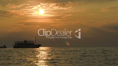 Tourist ship leaving pier at sunset
