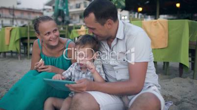 Family of three on resort with tablet PC