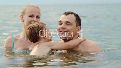 Lovely family with child bathing in sea