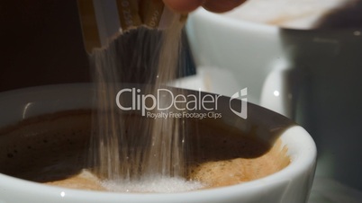 Putting  sugar into cup with coffee