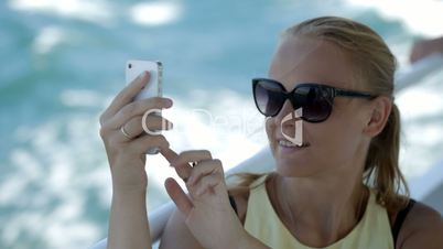 Woman making selfie with smatphone on the boat