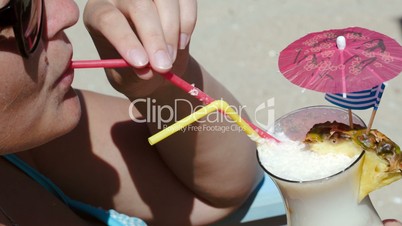 Woman enjoying summer day with cocktail on beach