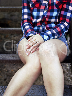 Young girl is sitting on the stairs outdoors