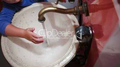 Child washing hands in vintage sink