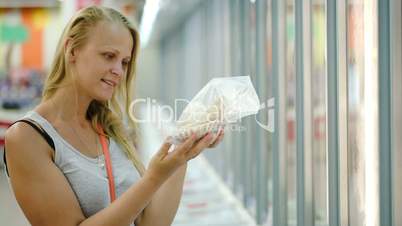 Woman taking product from fridge in store