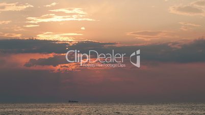 Timelapse of sunset over sea and sailing ship