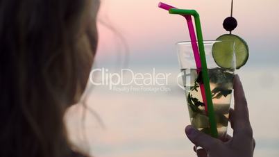 Woman drinking mojito with a straw