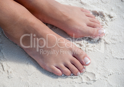 Relaxing at a beach, with beautiful woman feet in the warm sand