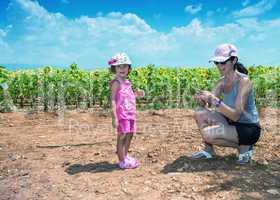 Mother and daughter enjoying outdoor with sunflowers field