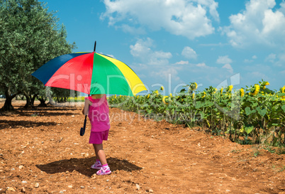 Child playing outdoor with colourful umbrella