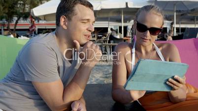 Man and woman with tablet computer on the beach