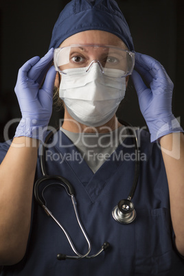 Female Doctor or Nurse Putting on Protective Facial Wear